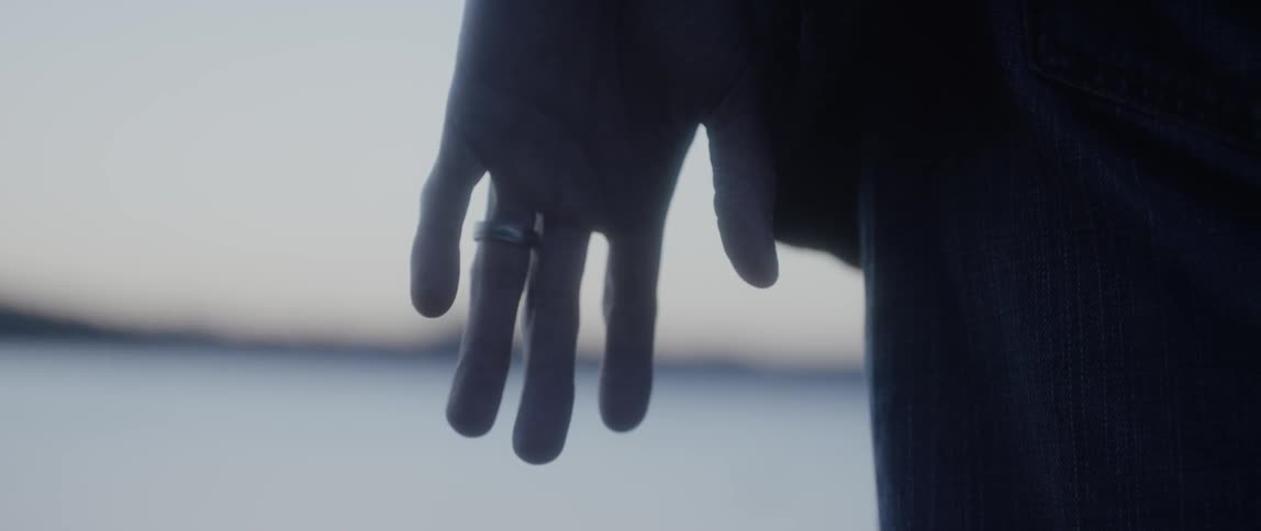 Persons hand turning at their side with a ring on their ring finger
