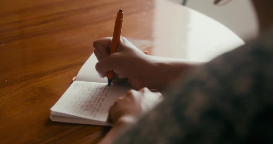 Hand with a pen writing in a notebook