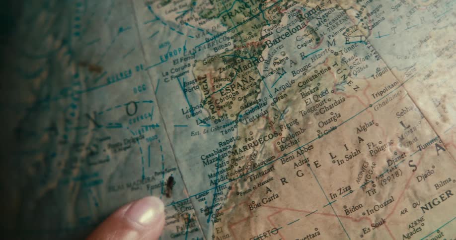 Persons finger pointing at a globe