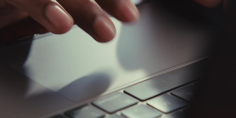 Person controls a laptop computer by using its touch pad
