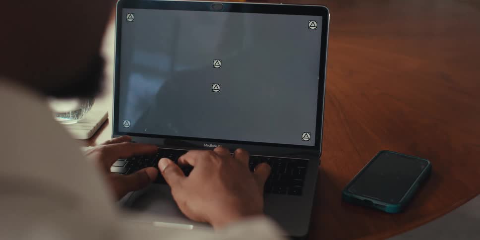 Pair of hands typing on a laptop and then picking up a smartphone
