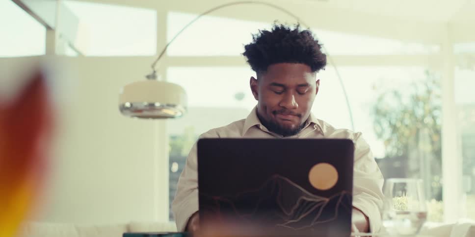 Man in a room working with a laptop on the table