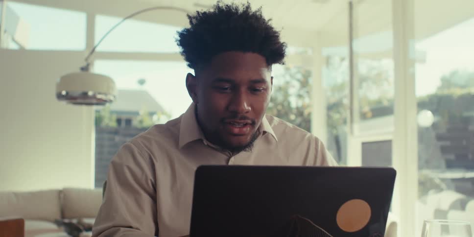 Smiling man in front of a laptop