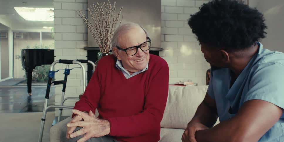Man sitting next to an elderly gentleman talking