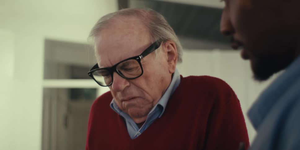 An elderly person is listening to a caregiver in a modern spacious living room