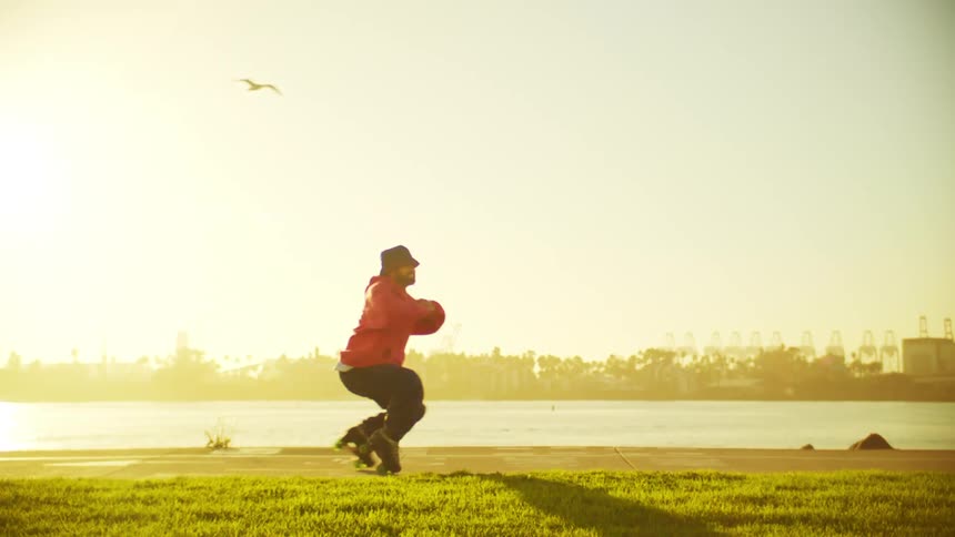 A bird flies over a man dancing on roller skates