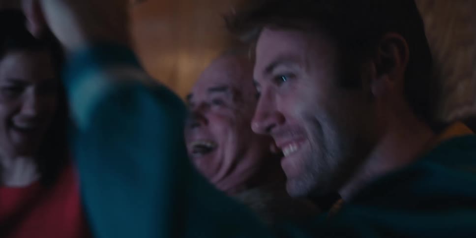 People are laughing and cheering at the television