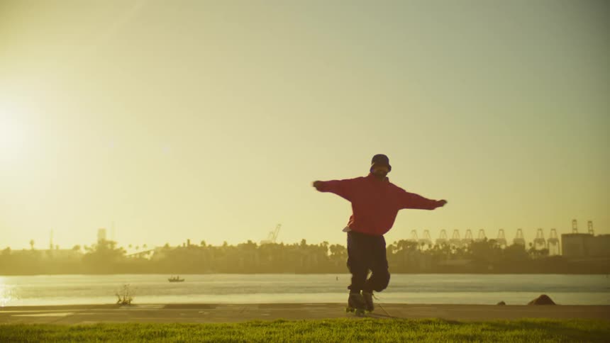 Man in an outdoor park at sunset dancing on roller skates