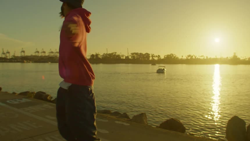 Man rollerblading and dancing at the same time by a lake