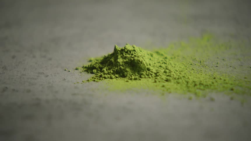 A closeup shot of vibrant green matcha powder shows its fine texture