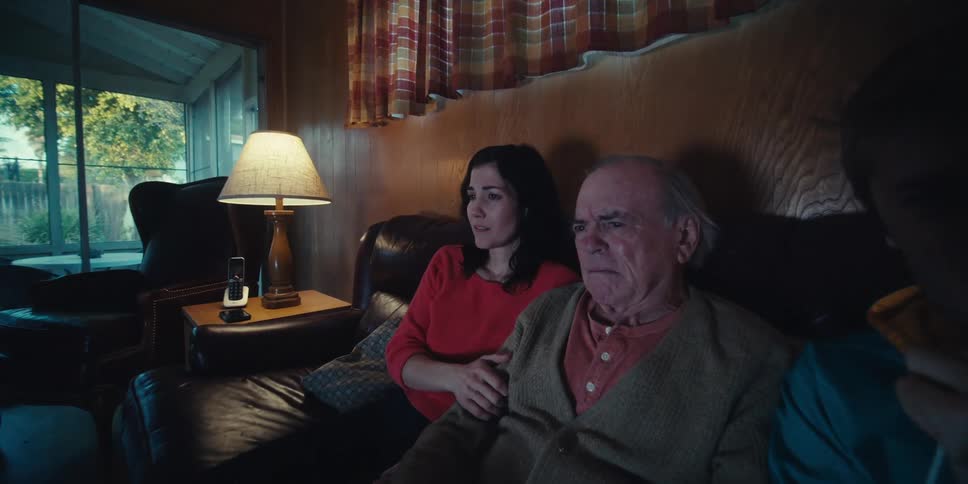 Family sits at home watching a sad movie