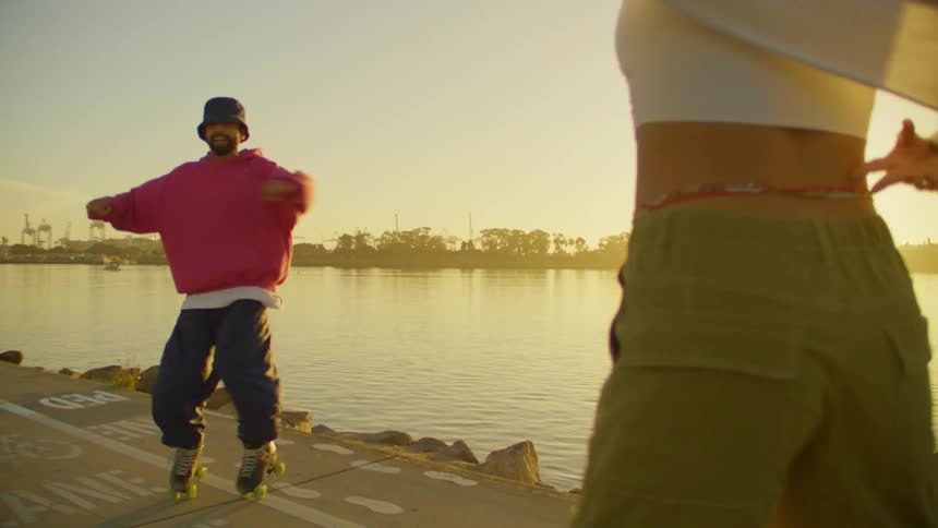 A man and woman spin side by side on roller blades