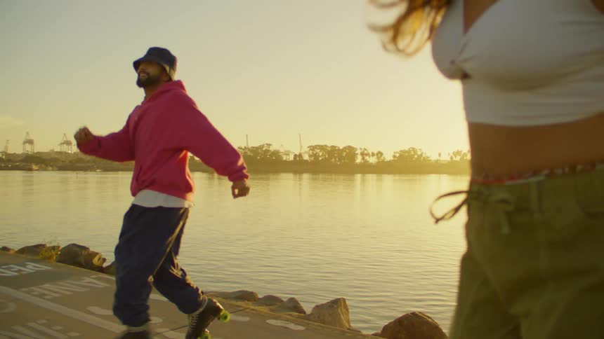 A man and woman dance together with roller skates