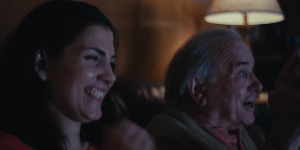 People laugh while watching a television show