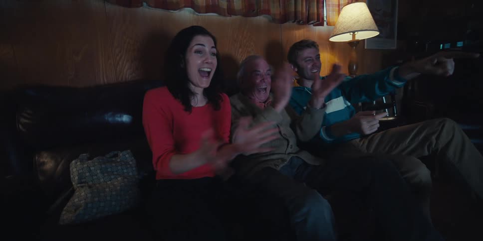 People cheer while watching television