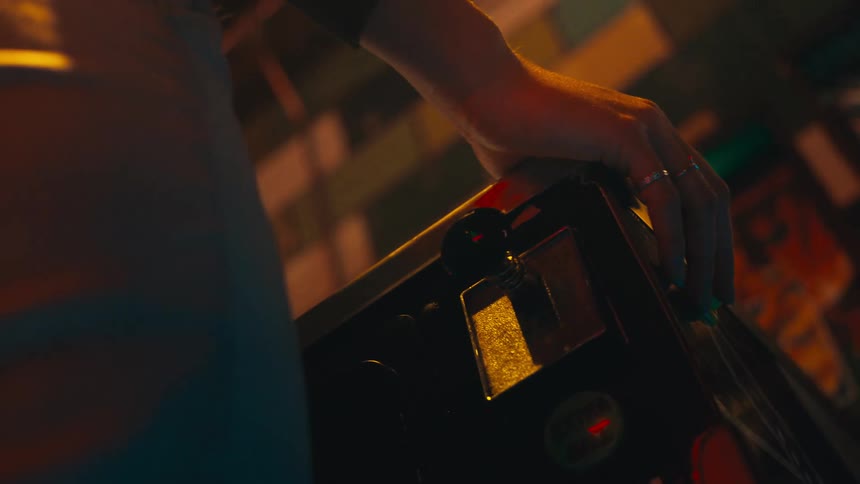 Hand of a person operating an arcade machine
