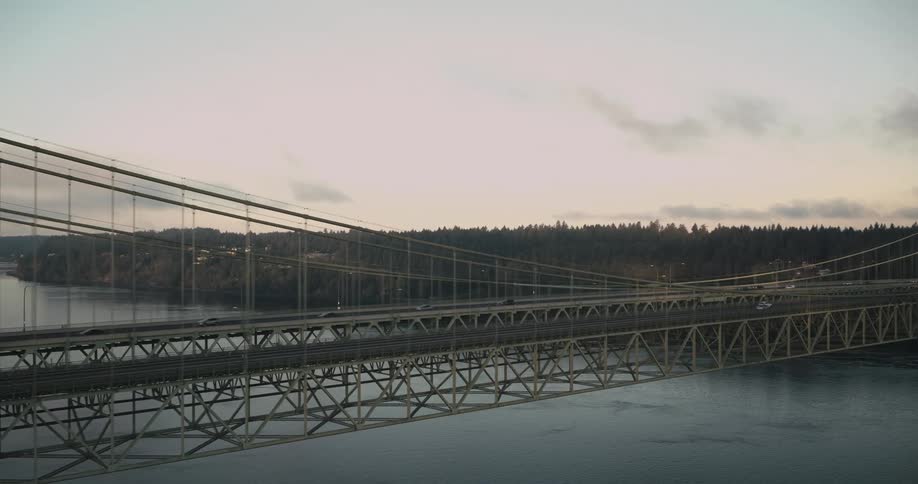 Aerial aerial view of metal suspension bridges over a sea channel and vehicle traffic