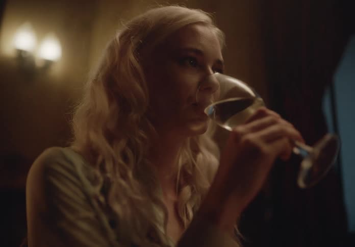 Blonde woman sitting in a restaurant having a drink