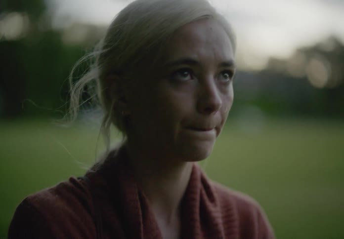 Woman walking outdoors with a dejected expression