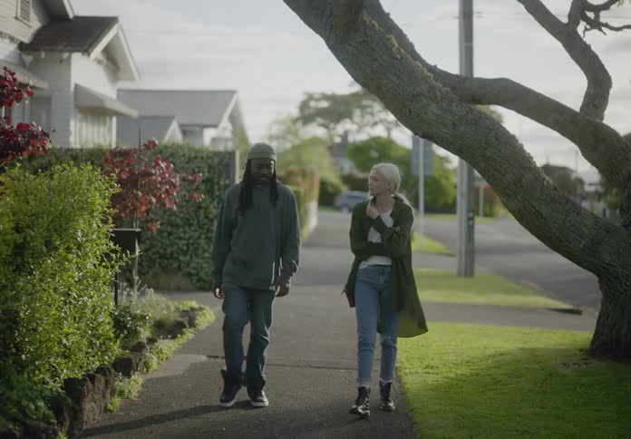 Friends talk as they walk on the sidewalk