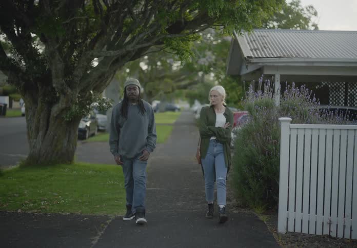 A man and woman are walking and talking in town