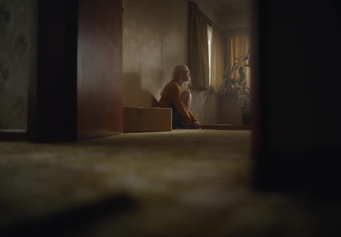 Woman sitting on the living room floor depressed