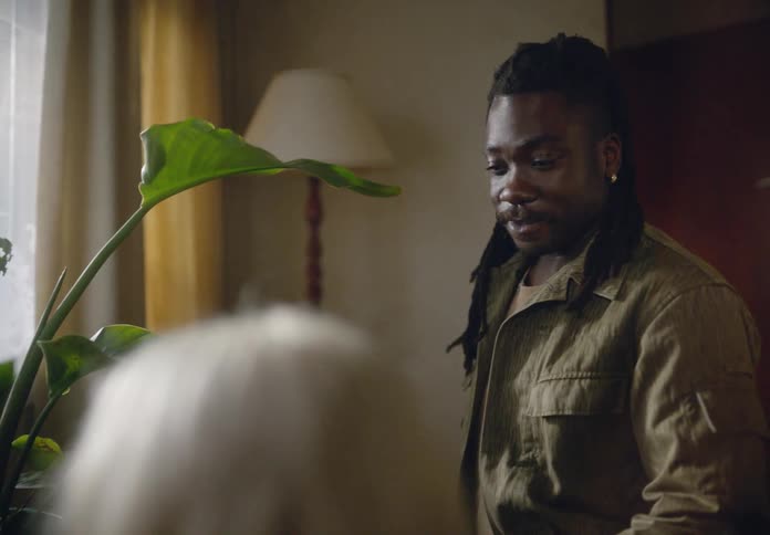 Happy man handing a potted plant to a woman next to him