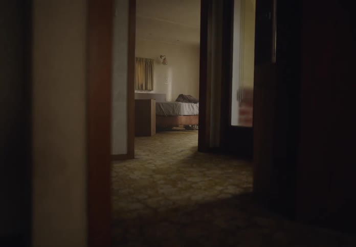 Woman lies down on the bed temporarily before moving a box into the hall