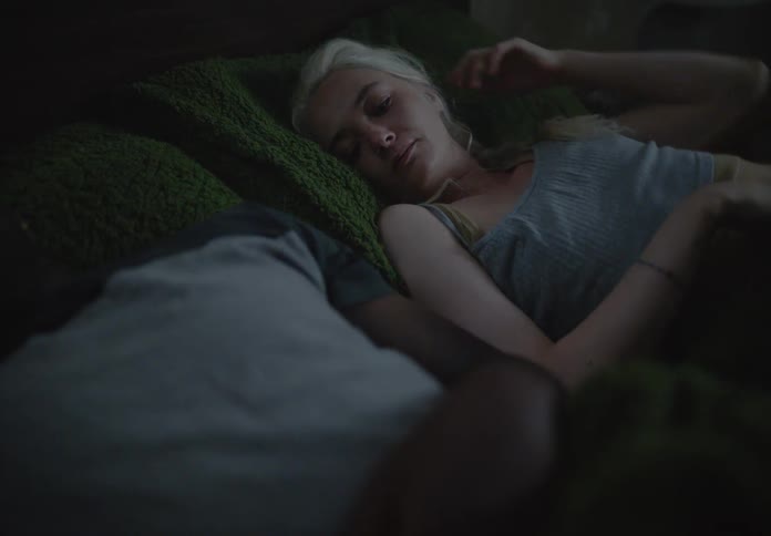 Woman lying in bed tries to hug her partner but is rejected