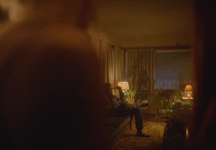 Woman watching a man sitting on the sofa in the living room