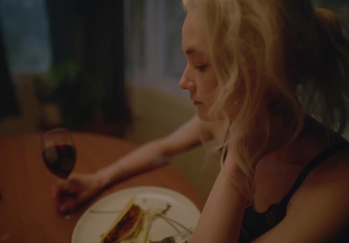 A clip of a sad lady drinking and dinning alone
