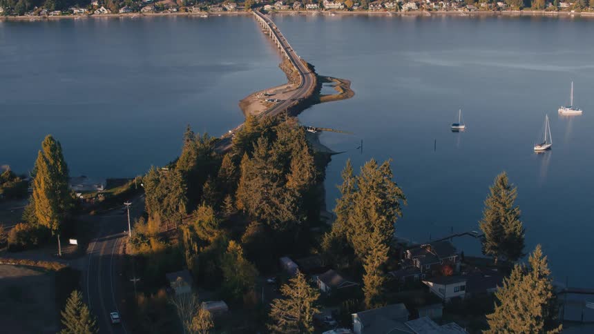 Aerial view of a highway connecting to a bridge that crosses a river connecting cities