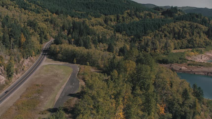 Aerial view of highways winding through mountainous areas with dense forests