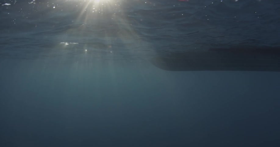 A boat is filmed from underneath the water