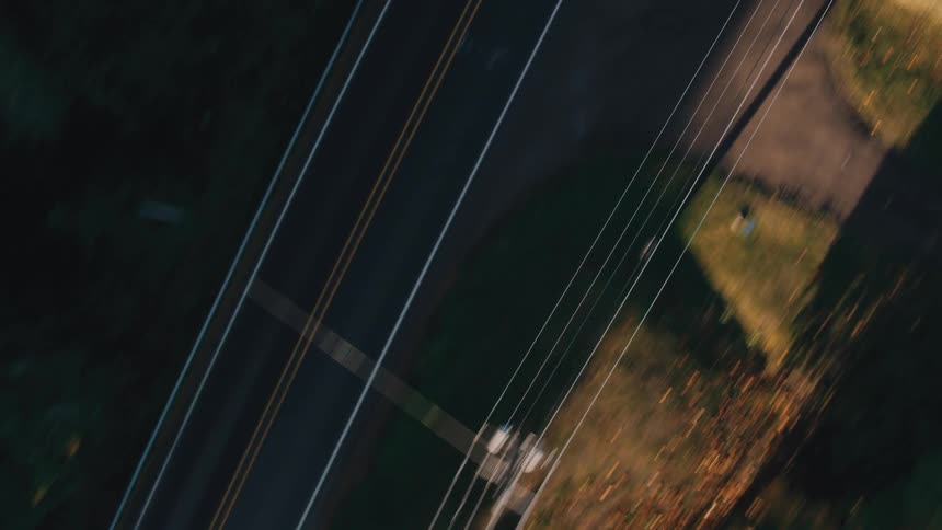 Highway parallels power lines while passing through the countryside on an autumn day