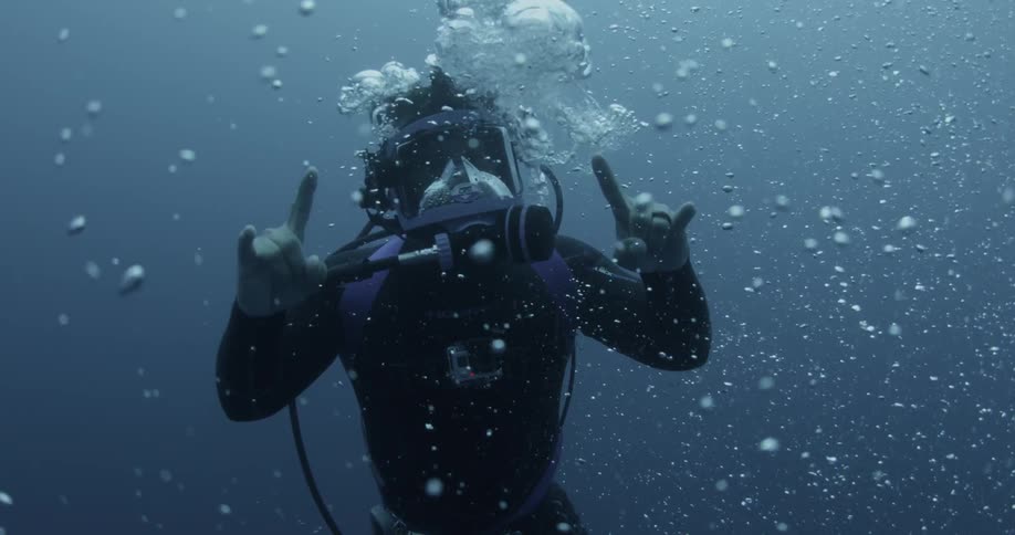 A scuba diver underwater making hand gestures