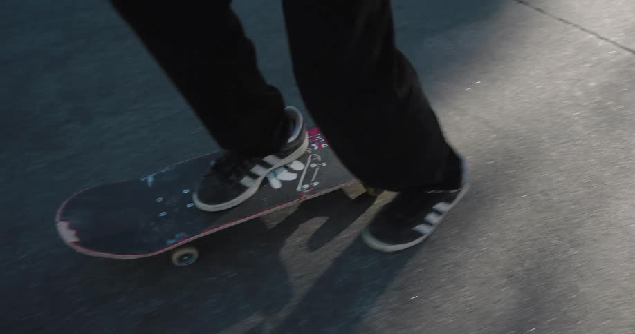 A teenage boy skateboards on a residential street on a sunny day