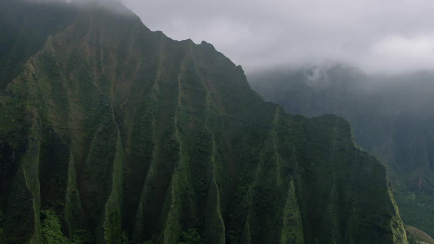 Landscape of steep greenish mountains seen on a cloudy day