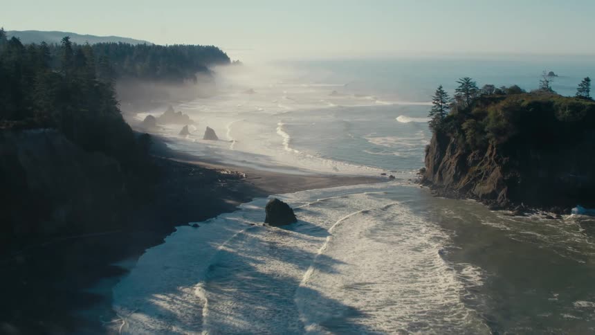 The crashing waves on the shore is causing a fog in the air