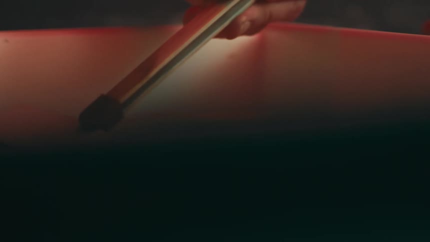 Hand with a spatula picking up a photograph of a liquid container