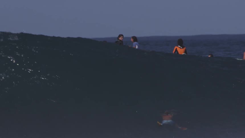 People are floating on a wave on their boards