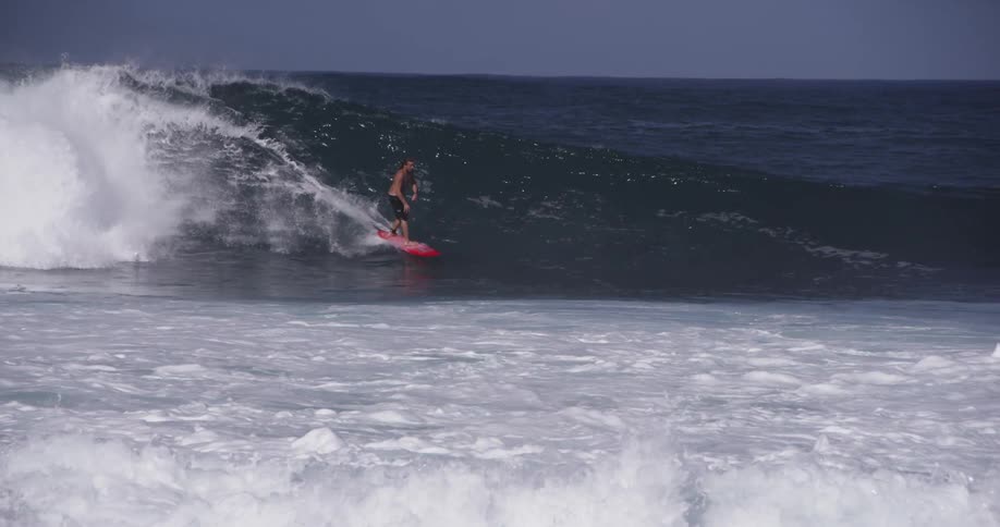 A man is surfing a large wave