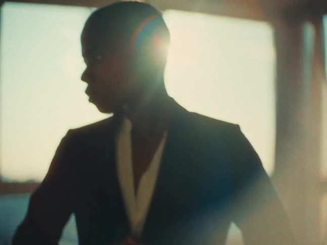 A clip of woman putting on a jacket with lens flare