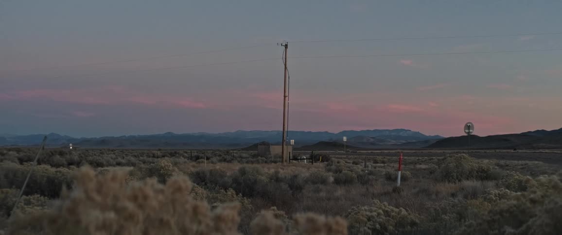 A power line runs through a long field
