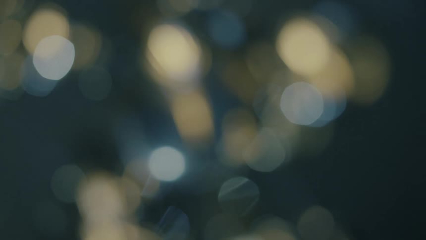 Outoffocus lights create a sparkling abstract pattern against a dark background with a hint of a rounded form in the center