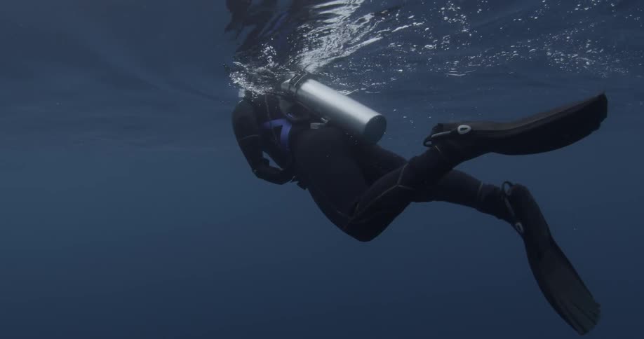 Scuba diver swimming at the surface of the water