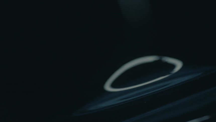 A close up of the surface of a glass bowl reflecting dim lights