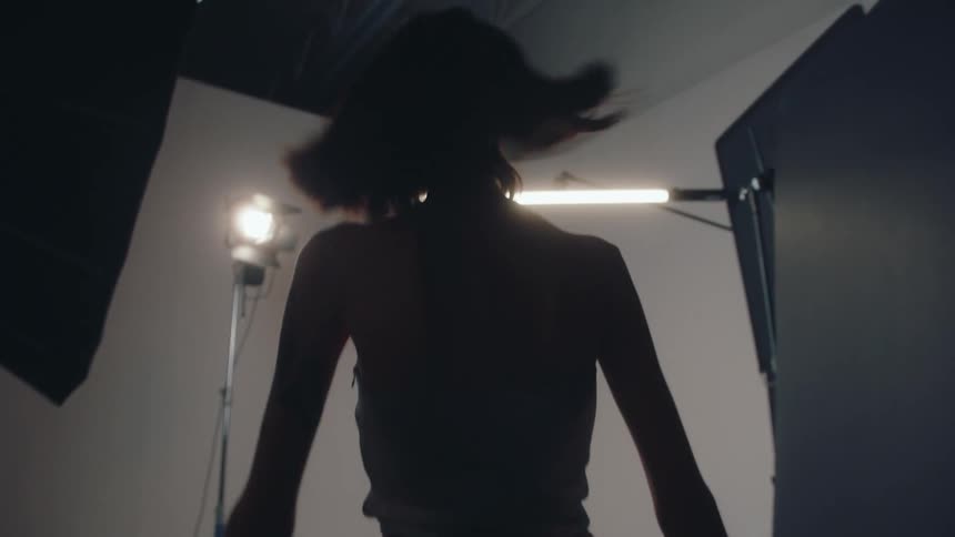 A model walks back and forth posing in the studio
