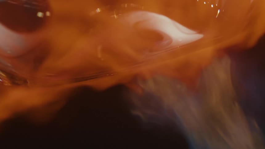 A glowing orange flame of fire hitting a melting object