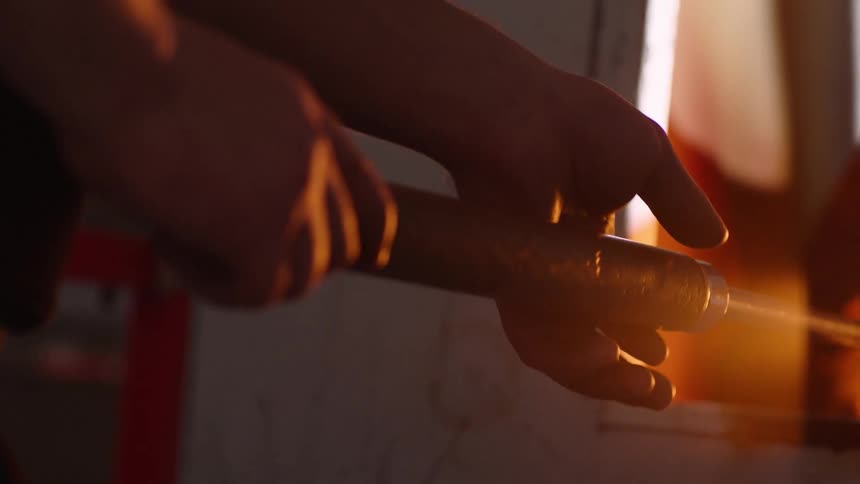 A person spins a rod in the hot oven